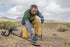 lifestyle pic of man digging using garrett goldmaster24k metal detector
