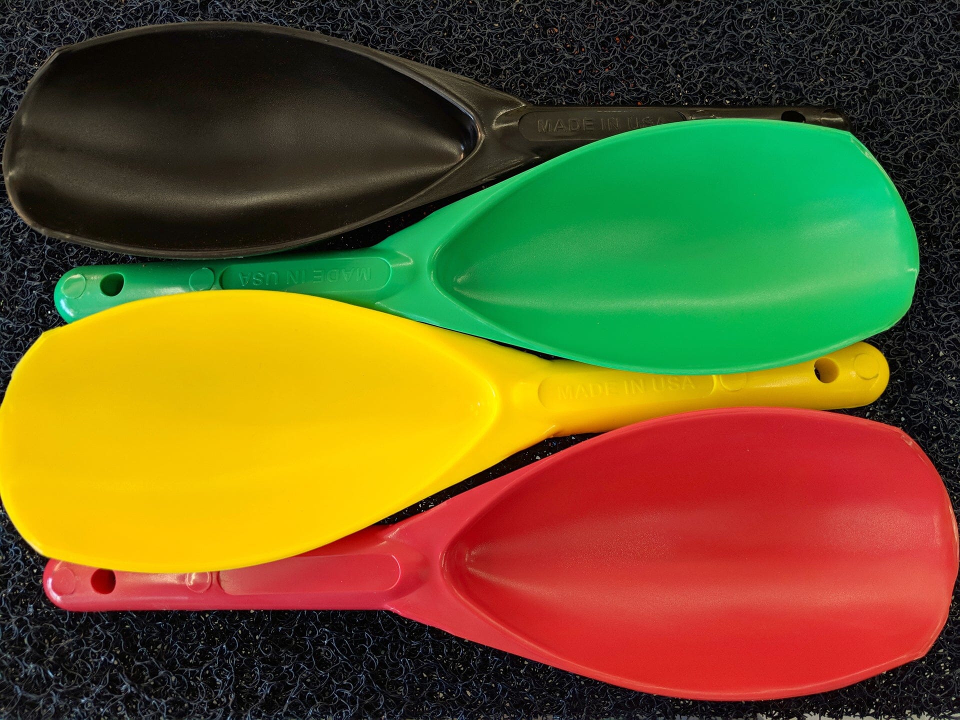 Top view of four gold nugget prospecting scoops, red, yellow, green, and black